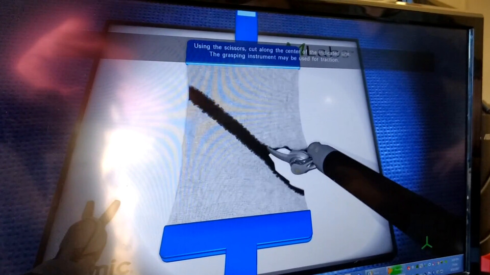 Video: scissors cutting a cloth sheet along a marked line in the pattern-cutting exercise