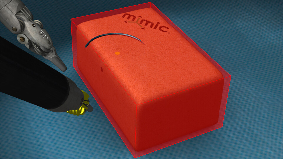 Translucent red axis-aligned bounding box drawn around an orange foam block beside two robotic instruments