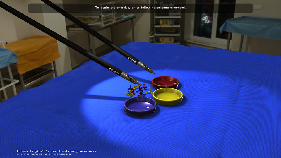 Pick-and-place exercise in a simulated operating room, with instruments reaching into a spotlight on three colored dishes