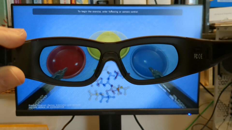 Video: active shutter glasses held in front of a monitor showing the pick-and-place exercise in active 3D stereo